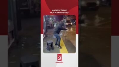 Buca’da bir vatandaş, yağış sonrası oluşan su birikintisinde balık tutmaya