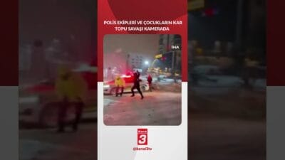 Görev başındaki trafik polisleri, kar topu oynayan çocukların neşesine ortak