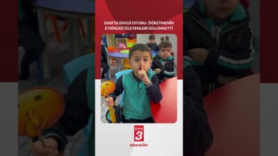 Bir öğretmenin sınıfta öğrencilerine emoji kartı seçtirerek yüz ifadelerini taklit
