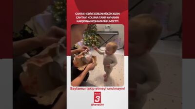 Çanta hediye edilen küçük kızın çantayı koluna takıp aynanın karşısına