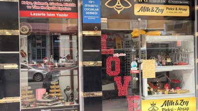 Afyonkarahisar kent merkezinde bir işletmenin vitrin camına asılan esprili yazı,